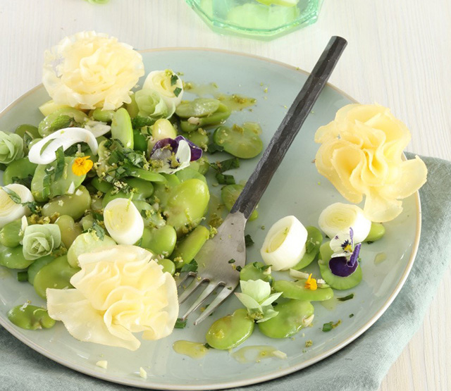 Salade de fèves aux fleurs comestibles couronnée de rosettes de Tête de Moine AOP